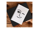 DENY Designs Wink Face by Mambo Art Studio Professional Notebooks, 5.5" x 8.25", Dotted, 40 Sheets, White (68797-NOBS01)